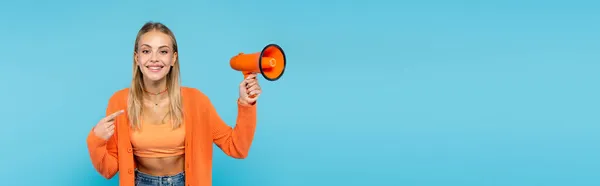 Glimlachende Blonde Vrouw Wijzend Naar Luidspreker Geïsoleerd Blauw Banner — Stockfoto