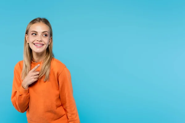 Glimlachende Blonde Vrouw Wijzend Met Vinger Geïsoleerd Blauw — Stockfoto