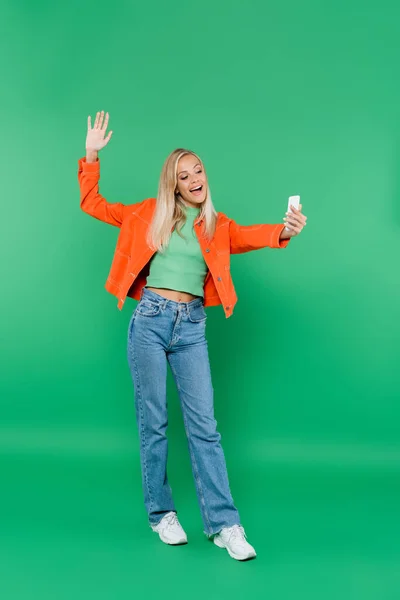 Vista Completa Mujer Alegre Moda Saludando Mano Mientras Toma Selfie — Foto de Stock