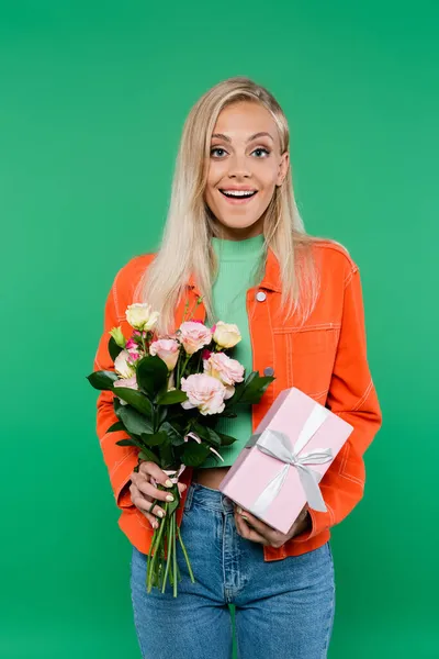 一个金发碧眼的女人 带着新鲜的花束和礼品盒 看着被绿色隔离的相机 — 图库照片
