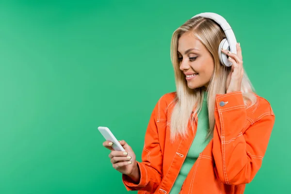 Smiling Blonde Woman Looking Mobile Phone While Listening Music Headphones — Stock Photo, Image