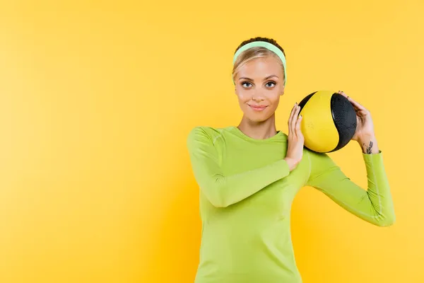 Улыбающаяся Спортивная Женщина Смотрящая Камеру Время Тренировки Мячом Изолированным Желтом — стоковое фото