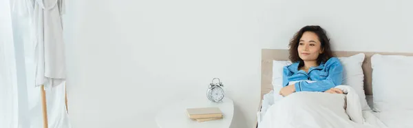 Брюнетка Женщина Лежит Постели Возле Прикроватного Столика Книгами Будильником Баннер — стоковое фото
