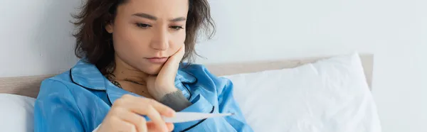Άρρωστη Νεαρή Γυναίκα Που Κοιτάζει Ηλεκτρονικό Θερμόμετρο Πανό — Φωτογραφία Αρχείου