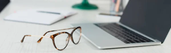 Gafas Cerca Ordenador Portátil Borroso Con Pantalla Blanco Escritorio Bandera — Foto de Stock