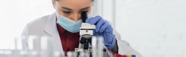 의료용 마스크와 라텍스 장갑을 착용하고 실험실에서 현미경을 과학자 현수막 — 스톡 사진