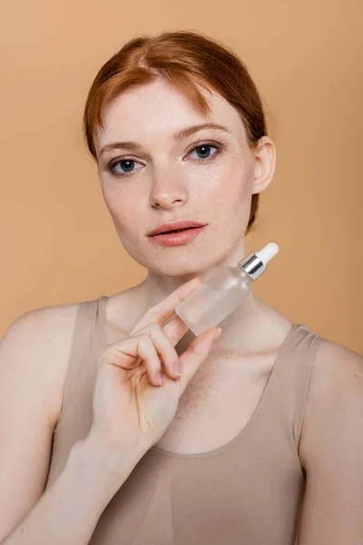 Jeune Femme Rousse Rousse Tenant Sérum Cosmétique Isolé Sur Beige — Photo