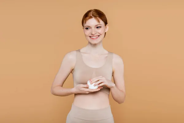 Cheerful Redhead Woman Top Holding Jar Cosmetic Cream Isolated Beige — Stock Photo, Image