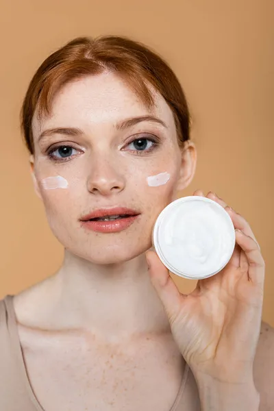 Young Redhead Woman Showing Container Cosmetic Cream Isolated Beige — Stock Photo, Image