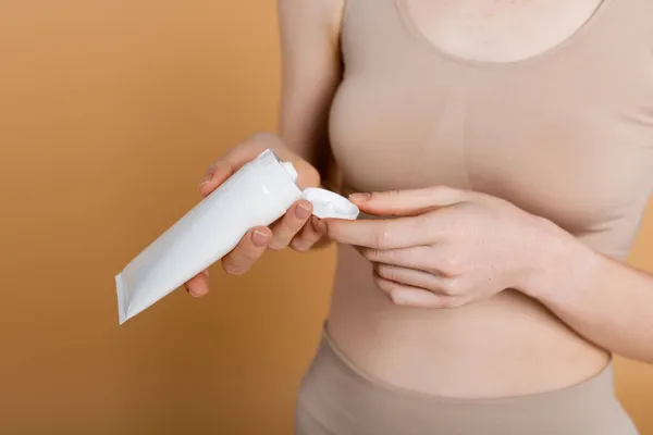 Cropped View Tube Cream Hands Blurred Woman Beige Background — Stock Photo, Image