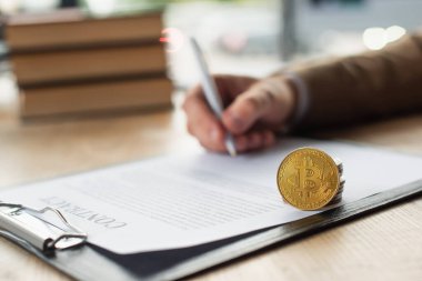 KYIV, UKRAINE - 22 Eylül 2021: para ve bitcoin, yolsuzlukla mücadele konsepti yakınındaki anlaşmanın imzalanması