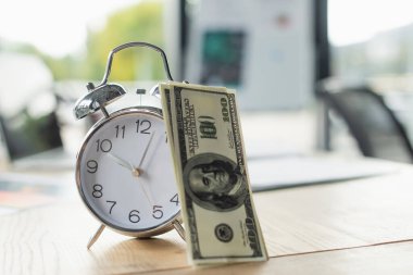 KYIV, UKRAINE - 22 Eylül 2021: Ofisteki retro alarm saatinin yanındaki dolar banknotları, yolsuzlukla mücadele konsepti