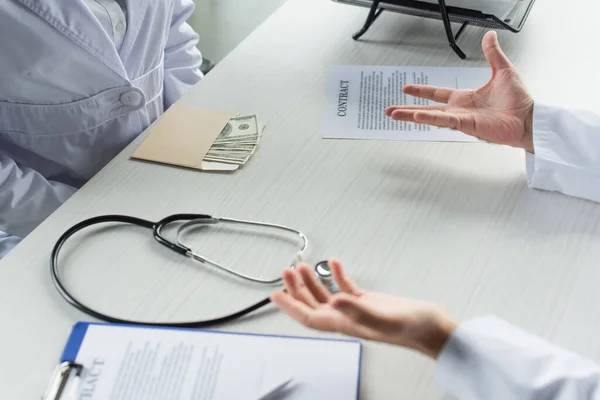 Visão Cortada Envelope Com Dólares Perto Paciente Médico Com Palmas — Fotografia de Stock