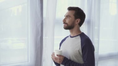 Bardak tutan ve gülümseyen bir adam. 