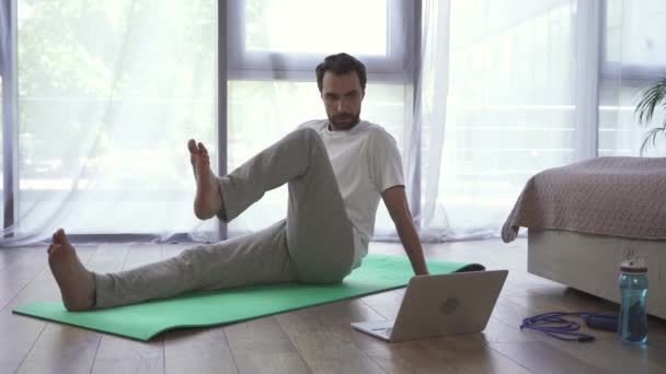 Homem Exercitando Tapete Fitness Perto Laptop Quarto — Vídeo de Stock