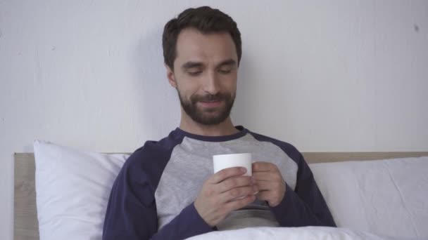 Glimlachende Man Met Een Kop Koffie Bed Ochtend — Stockvideo