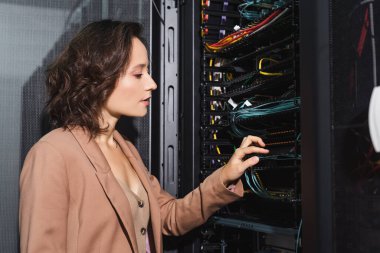 technician checking wires in server while working in data center clipart
