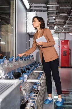 Veri merkezinde soğutma sisteminin yanında dururken dijital tablet tutan teknik yönetici