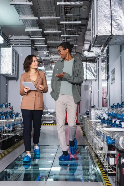 Sonriente Técnico Afroamericano Señalando Con Mano Mientras Habla Con Colega —  Fotos de Stock