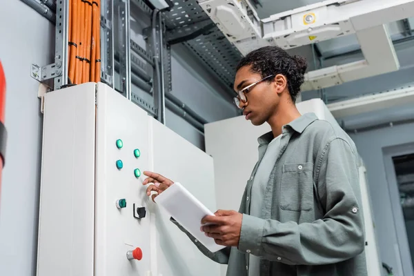 Young African American Technician Digital Tablet Pushing Button Switchboard Data — Stock Photo, Image