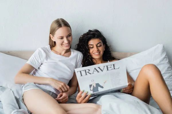 快乐的女同性恋夫妇在卧室看旅游报纸 — 图库照片