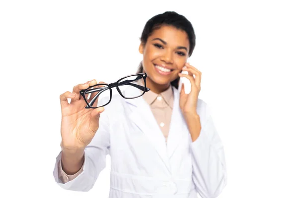Óculos Mão Oculista Afro Americano Desfocado Falando Smartphone Isolado Branco — Fotografia de Stock