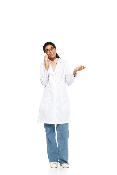 全长的笑着的非洲裔美国眼科医生在白色背景下对着手机讲话 — 图库照片