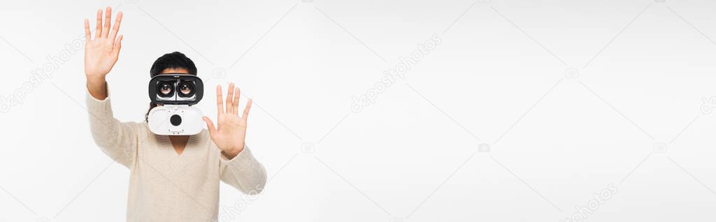 African american woman in sweater and vr headset gesturing isolated on white, banner 