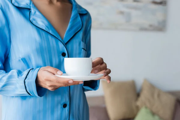 Vista Recortada Mujer Afroamericana Sosteniendo Taza Café Platillo Dormitorio — Foto de Stock