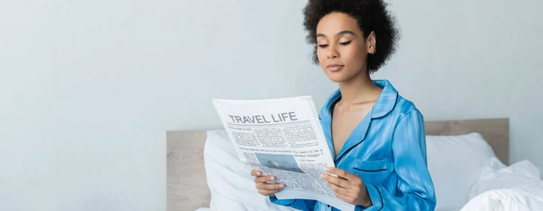 Αφροαμερικανή Γυναίκα Πιτζάμες Διαβάζει Ταξιδιωτική Εφημερίδα Στην Κρεβατοκάμαρα Πανό — Φωτογραφία Αρχείου