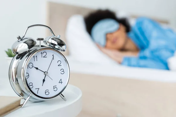 アフリカ系アメリカ人女性のベッドの近くの目覚まし時計 — ストック写真