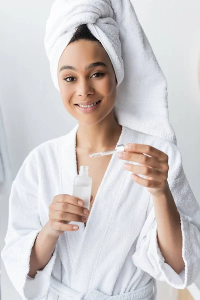 Mulher Afro Americana Positiva Roupão Banho Branco Segurando Garrafa Com — Fotografia de Stock