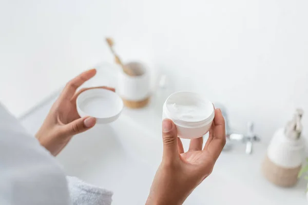 Vista Recortada Mujer Afroamericana Sosteniendo Contenedor Con Crema Facial Baño —  Fotos de Stock