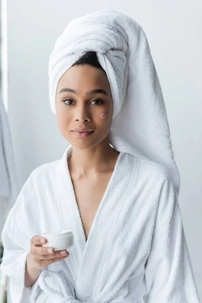 Mujer Afroamericana Bata Baño Sosteniendo Contenedor Con Crema Facial — Foto de Stock