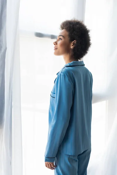 Vista Lateral Mulher Americana Africana Pijama Azul Perto Cortinas — Fotografia de Stock