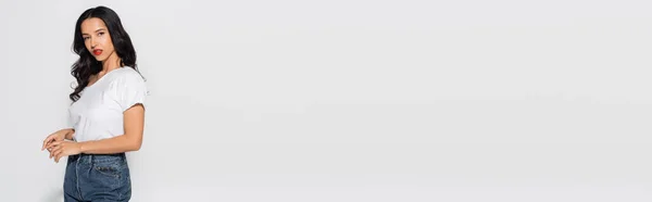 Красивая Брюнетка Белой Футболке Джинсах Смотрящая Камеру Сером Баннер — стоковое фото
