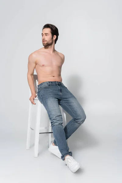 Vue Pleine Longueur Homme Torse Jeans Regardant Loin Tout Posant — Photo