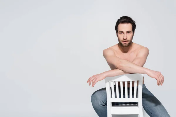 Genç Seksi Üstsüz Adam Beyaz Sandalyede Oturuyor Gri Kameraya Bakıyor — Stok fotoğraf