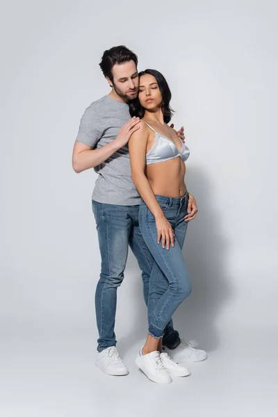 Visão Comprimento Total Homem Abraçando Mulher Jeans Sutiã Cinza — Fotografia de Stock
