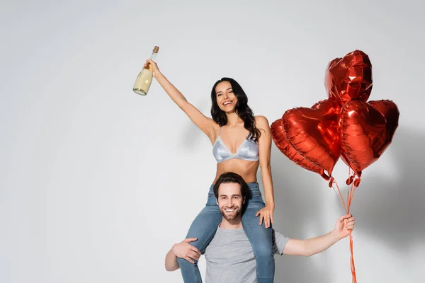 Man Heart Shaped Balloons Piggybacking Sexy Happy Woman Champagne Bottle — Stock Photo, Image