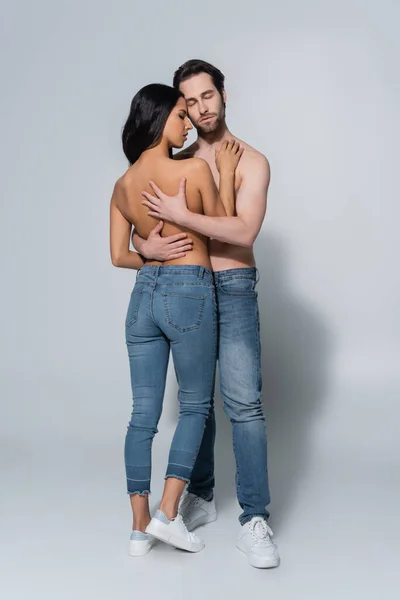 Vista Completa Mujer Hombre Sin Camisa Jeans Abrazándose Gris — Foto de Stock