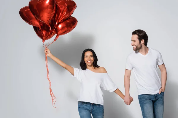 Cheerful Woman Heart Shaped Balloons Holding Hands Young Boyfriend Grey — Stock Photo, Image