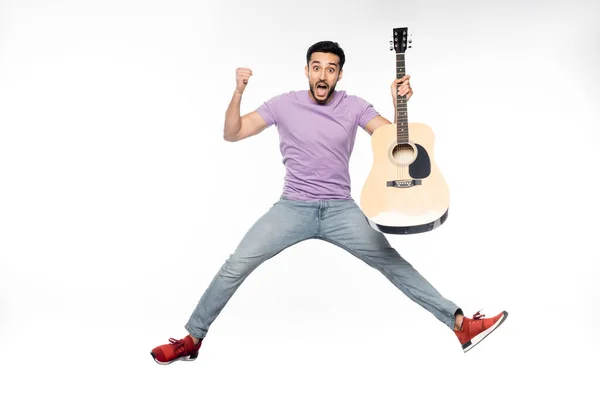 Überraschter Mann Blauer Jeans Und Lila Shirt Schwebt Mit Akustikgitarre — Stockfoto
