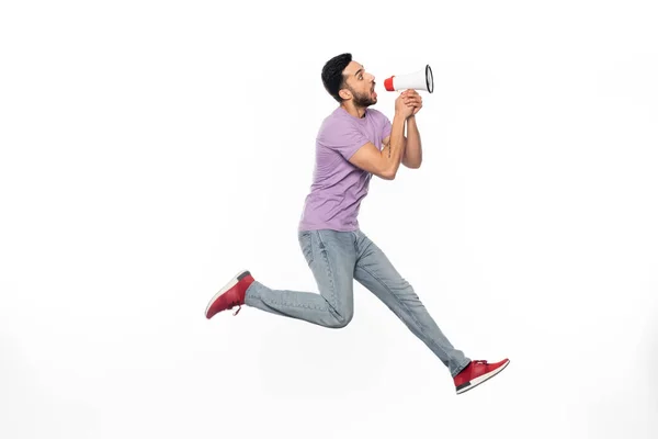 Happy Man Jeans Purple Shirt Levitating While Speaking Megaphone White — 图库照片