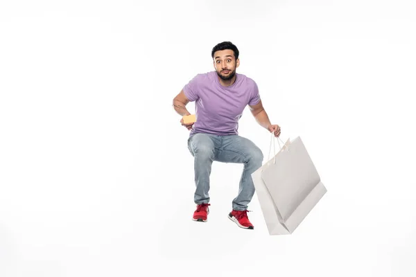 Homem Jeans Camiseta Roxa Levitar Enquanto Segurando Cartão Crédito Saco — Fotografia de Stock