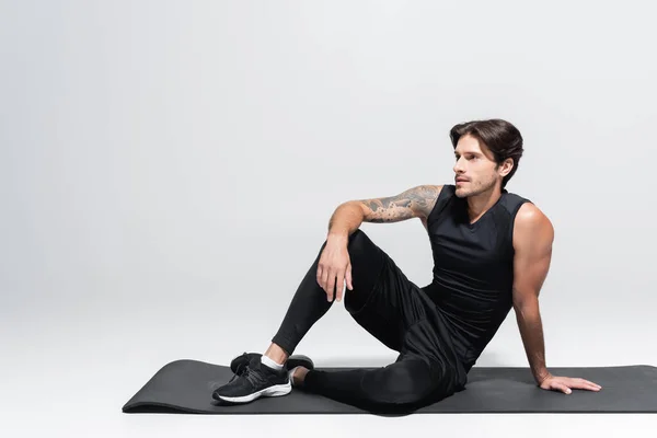 Sportsman Sitting Black Fitness Mat Grey Background — Stockfoto