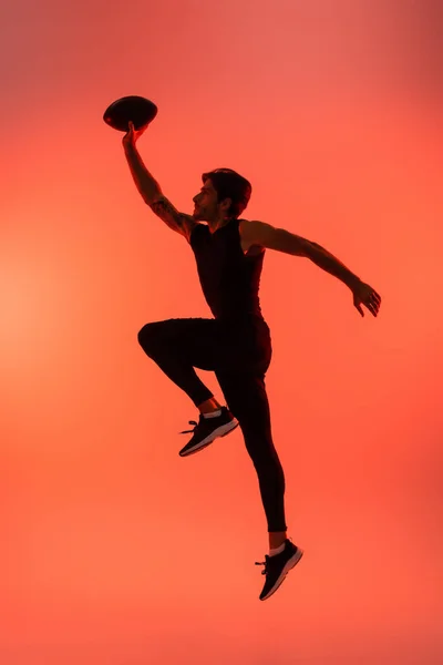 Side View Athletic Player Holding Rugby Ball While Jumping Isolated — Stockfoto