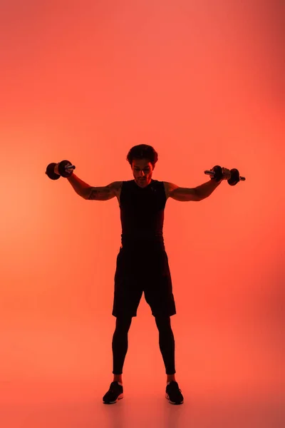 Entrenamiento Deportista Con Pesas Sobre Fondo Rojo —  Fotos de Stock