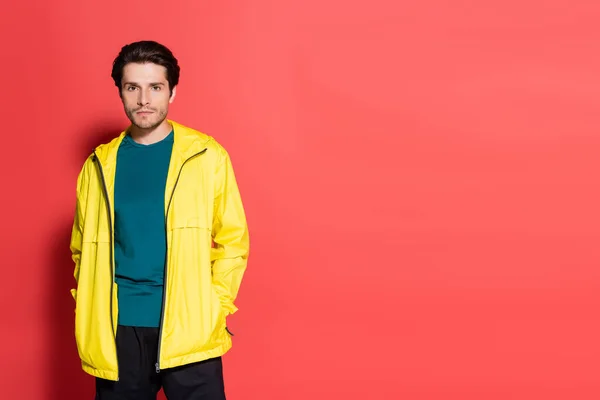 Brunette Sportsman Sports Jacket Looking Camera Red Background — Stockfoto