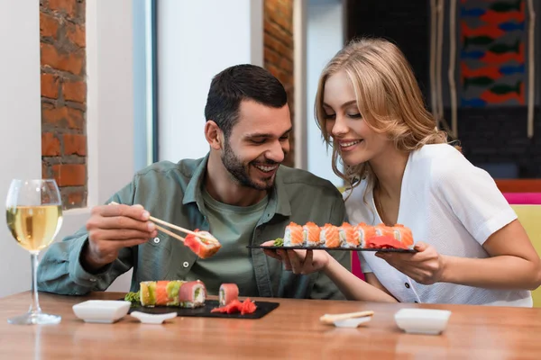 Smiling Woman Showing Delicious Sushi Rolls Boyfriend Dinner Restaurant — Stockfoto